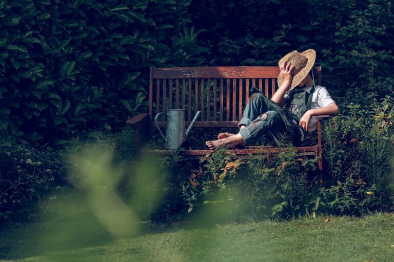 homme sur un banc dans son jardin