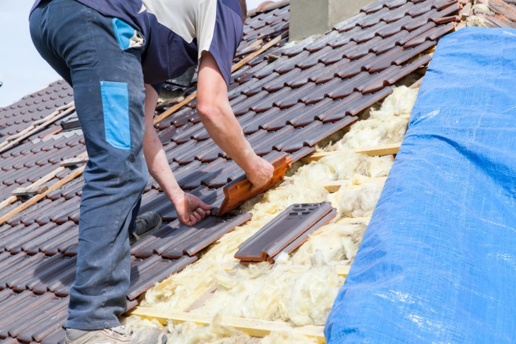Un couvreur travaillant sur la pose d'une toiture de maison