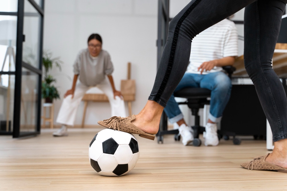 une femme mettant son pied sur un ballo de foot