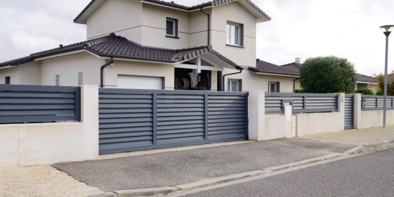 une devanture de maison avec portail et clôture