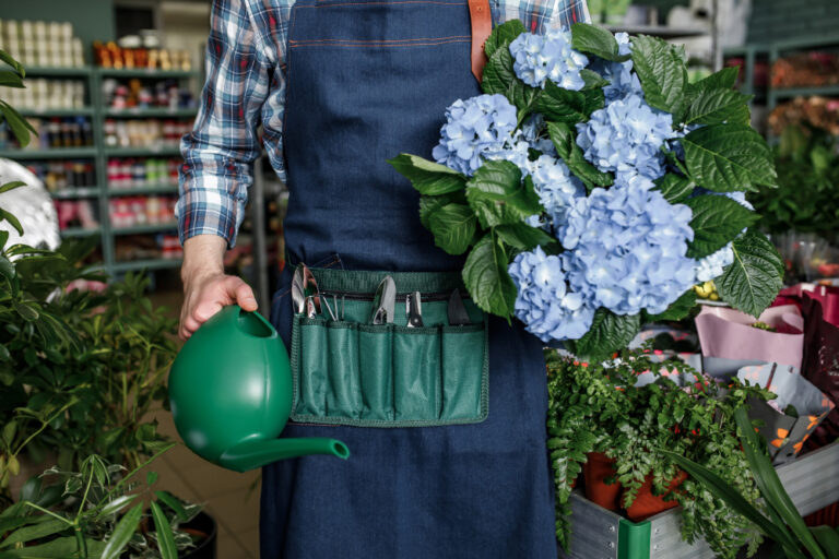 jardinier avec un bouquet de fleur et un arrosoir