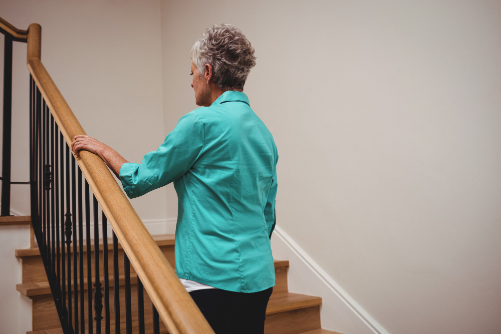 Personne âgée montant un escalier