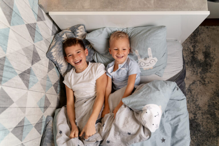 Deux enfants qui rigolent dans un lit