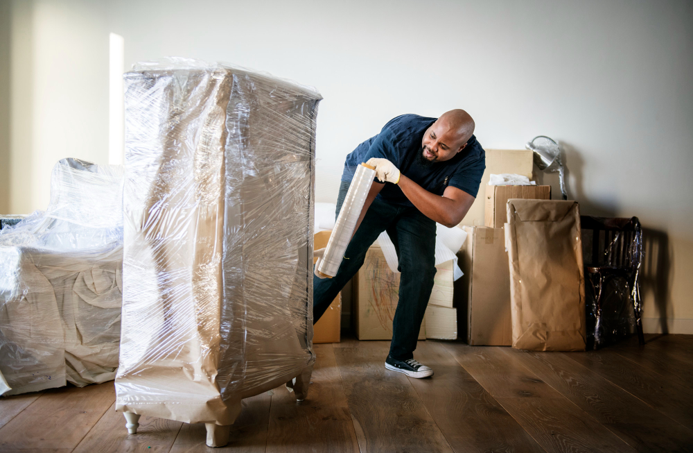 un homme déménageant un gros carton