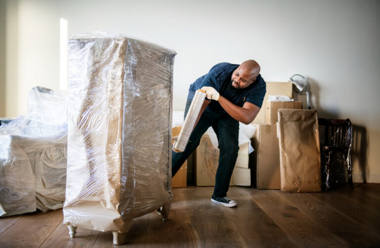 un homme fermant un carton de déménagement