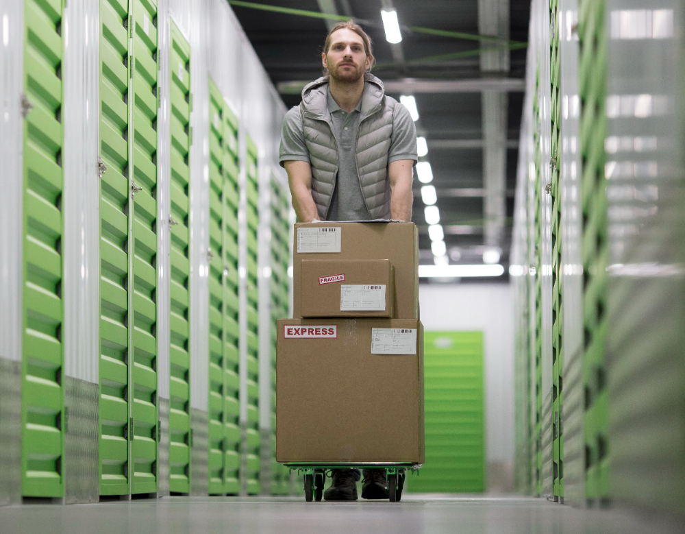 un homme transportant des cartons dans des boxs de stockage