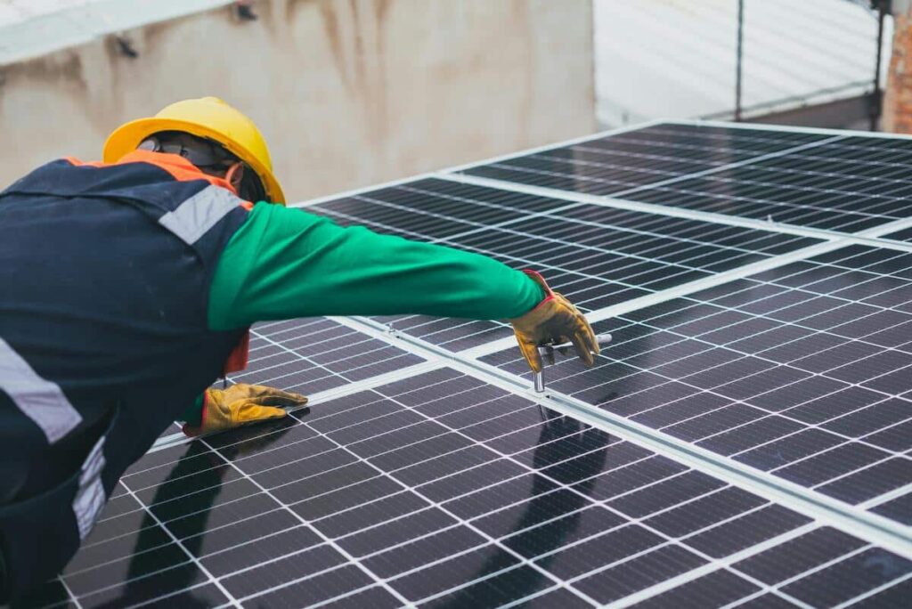 un artisan installe un panneau solaire