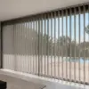 Store anti-chaleur &agrave; lames verticales install&eacute; sur une grande baie vitr&eacute;e